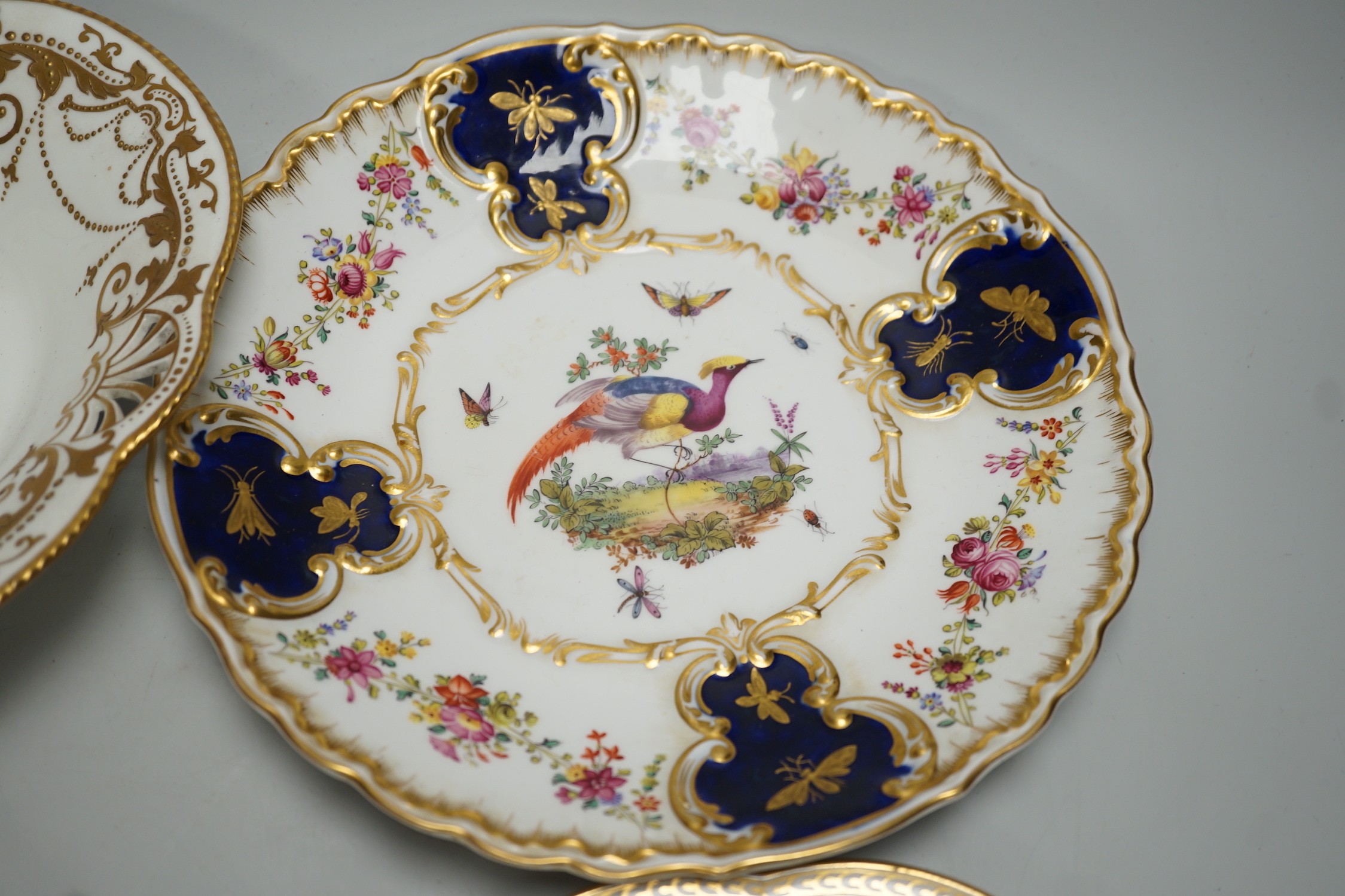 A Copeland plate decorated in Chelsea style with exotic birds on a mazarine blue ground, a similar plate probably Coalport, a Davenport plate with Windemere Lake and a Alderley pierced dish
